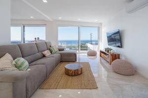 a living room with a couch and a coffee table at Villa Gold with ocean view, jacuzzi and private pool in Ribamar