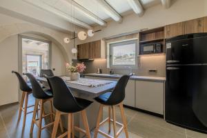 a kitchen with a black refrigerator and a table with chairs at Villa Lefkothea in Georgioupoli