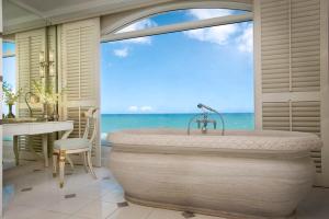 a bathtub in a room with a view of the ocean at The Oyster Box in Durban