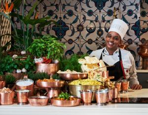 a chef is standing behind a buffet of food at The Oyster Box in Durban