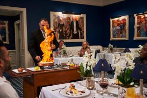 a man standing in a restaurant with a fire performer at The Oyster Box in Durban