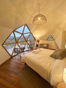a bedroom with a bed and a large window at Colmena EcoGlamping in Angastaco