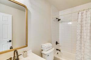 a bathroom with a sink and a toilet and a mirror at 1 Mi to Pioneer Crossing Casino Fernley Retreat! in Fernley +18 photos