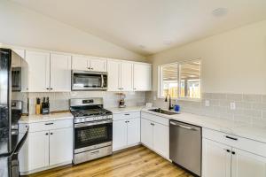 a kitchen with white cabinets and stainless steel appliances at 1 Mi to Pioneer Crossing Casino Fernley Retreat! in Fernley