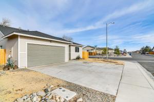 a house with a garage on the side of a street at 1 Mi to Pioneer Crossing Casino Fernley Retreat! in Fernley