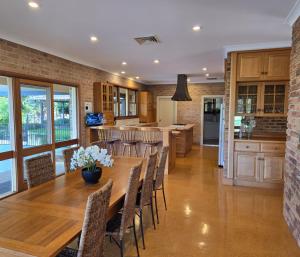 a kitchen and dining room with a wooden table and chairs at Capturing Breathtaking Retreat! in Denham Court