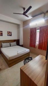 een slaapkamer met een bed en een plafondventilator bij Sk Residency in Bangalore