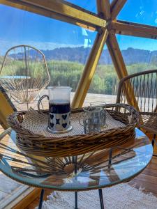 a glass table with a drink and two glasses on it at Colmena EcoGlamping in Angastaco +36 photos