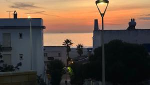 a street light in front of a building at sunset at TarifaMiCasa Mar Tirreno in Tarifa +13 photos