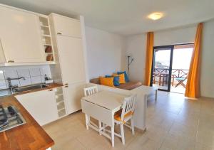 a kitchen and living room with a table and a couch at Apartamento Arriba, Casa-la-Costa in La Costa