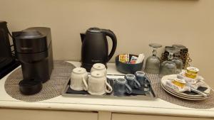 a counter with a coffee maker and cups on it at Dimora Largo Silvestro dell'Aquila- Centro Storico in LʼAquila
