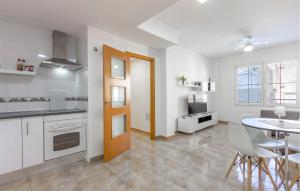 a kitchen and dining room with a table and chairs at Amazing Apartment In Santa Pola in Santa Pola +11 photos