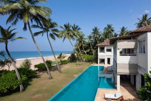 an aerial view of a villa with a swimming pool and the beach at Sri Villas in Bentota