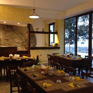 un comedor con mesas, sillas y ventanas en Locanda Del Drago, en Monreale