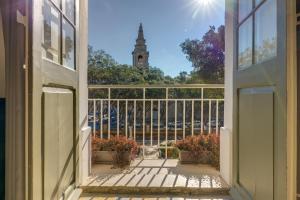 an open door to a balcony with a view of a church at Ellul Living in Il-Furjana