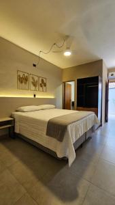 a bedroom with a large bed in a room at Caraguá Flat in Caraguatatuba