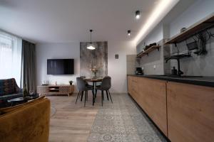 a kitchen and living room with a table and chairs at Laguna Beskidów Resort - Apartament Simple Comfort in Zarzecze