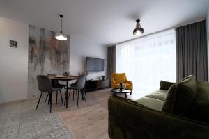 a living room with a couch and a table at Laguna Beskidów Resort - Apartament Simple Comfort in Zarzecze