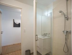 a white bathroom with a shower and a sink at Le Cocon de l'Artiste - moderne, artistique et cosy ! in Troyes +10 photos