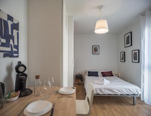 a living room with a bed and a table with a dining room at Le Cocon de l'Artiste - moderne, artistique et cosy ! in Troyes