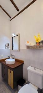 a bathroom with a white toilet and a sink at Suíte Kuta - Buddha House in Ilhabela +69 photos