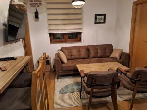 a living room with a couch and a table at Apartman Moj mir Jahorina in Jahorina