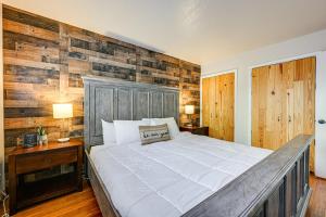 a bedroom with a large bed with a wooden wall at Walk to Giant Steps Mtn Retreat with Hot Tub Access in Brian Head +17 photos