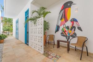 einen Flur mit Stühlen und ein Gemälde an der Wand in der Unterkunft Suíte Organic Cumbuco na Melhor Localização by CDH in Cumbuco