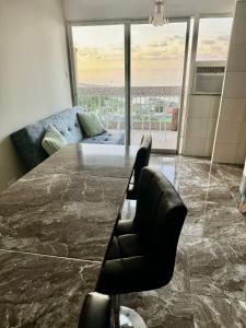 a dining room with a large marble table and a couch at Apartamento VistaMar in La Guaira