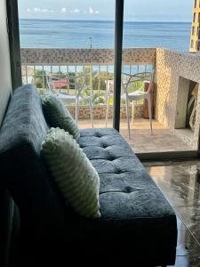 a couch in a living room with a view of the ocean at Apartamento VistaMar in La Guaira