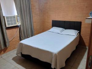 a bedroom with a bed and a window and a fan at Flat de 2 quartos com AR na área central de GV com conzinha completa-garagem-wifi-Bom p grupos ou familias ou empresas in Governador Valadares