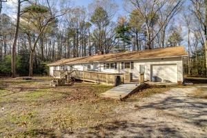 a small white house with a garage in a yard at Serene Delmar Nature Escape on 15 Acres! in Delmar