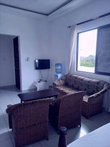 a living room with a couch and a television at Eden Breeze Appartments in Diani Beach