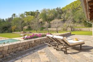 a patio with two lounge chairs next to a retaining wall at La Zalema in Esporles +52 photos