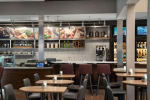 a restaurant with tables and chairs and a bar at Courtyard by Marriott Pleasanton in Pleasanton