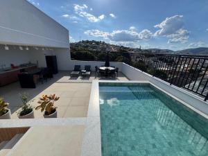 a balcony with a swimming pool on a building at Studio lindo com ar condicionado e piscina - Bela Vita - 104 in São Lourenço
