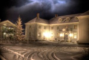 une grande maison avec un arbre de Noël en face dans l'établissement Hovde Gård, à Brekstad