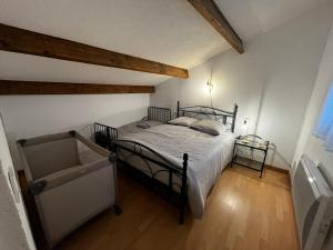 拉努韦勒港Maison de vacances à la mer的带床和木地板的卧室