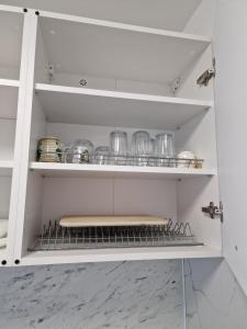 a kitchen shelf with dishes and utensils on it at Naujojo uosto butas in Klaipėda