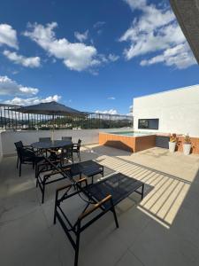 taras ze stołami i krzesłami na dachu w obiekcie Studio lindo com ar condicionado e piscina - Bela Vita - 104 w mieście São Lourenço