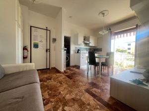 a living room and kitchen with a couch and a table at APARTMENT Aurora & Nicole IDEAL per bike 1 free parkings large e wi-fi free e x family mtb climbing con terazza vista mare in Pietra Ligure