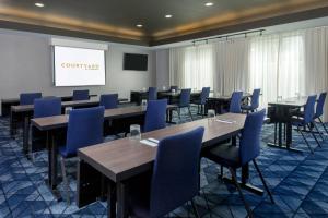 a conference room with tables and chairs and a screen at Courtyard Tallahassee North/I-10 Capital Circle in Tallahassee +29 photos