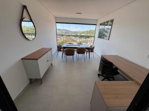a kitchen and dining room with a table and chairs at Studio lindo com ar condicionado e piscina - Bela Vita - 104 in São Lourenço