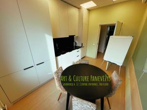 a room with a table and chairs and a kitchen at Art & Culture Panevėžys in Panevėžys