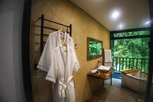 a bathroom with a white robe hanging on a wall at I am Boutique Hotel Campos do Jordão by Unna in Campos do Jordão