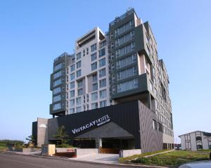 um edifício branco alto com um cartaz em Vistacay Hotel Worldcup em Seogwipo