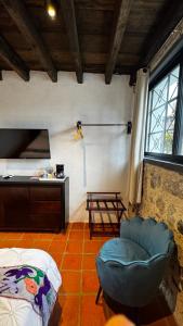 a living room with a chair and a table at La Peña Hotel Boutique & SPA in Cuetzalán del Progreso