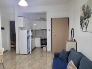 a living room with a blue couch and a kitchen at JL apartament tirana resort in Radhimë +13 photos