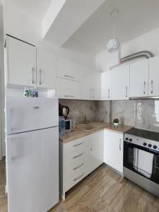a white kitchen with white appliances and white cabinets at JL apartament tirana resort in Radhimë