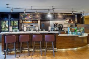 a bar in a restaurant with three bar stools at Courtyard Knoxville Cedar Bluff in Knoxville